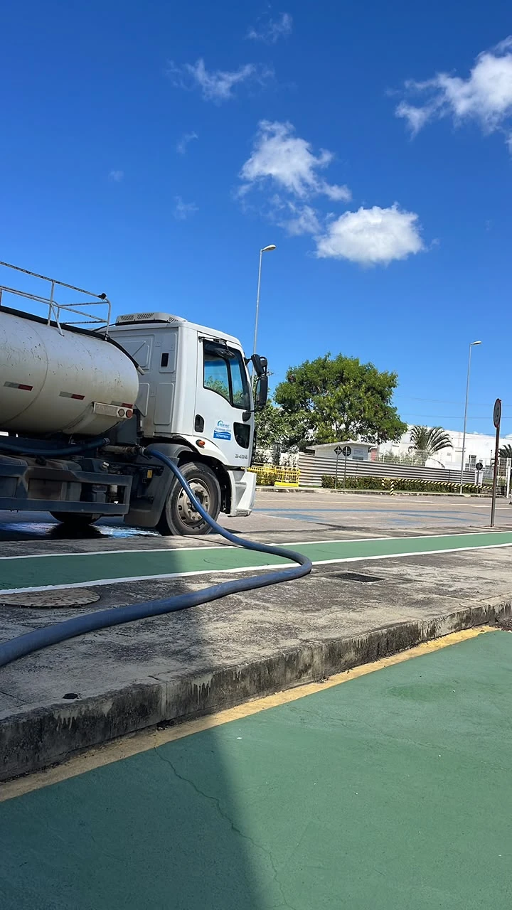 Caminhão-pipa Água Mac com mangueira em operação